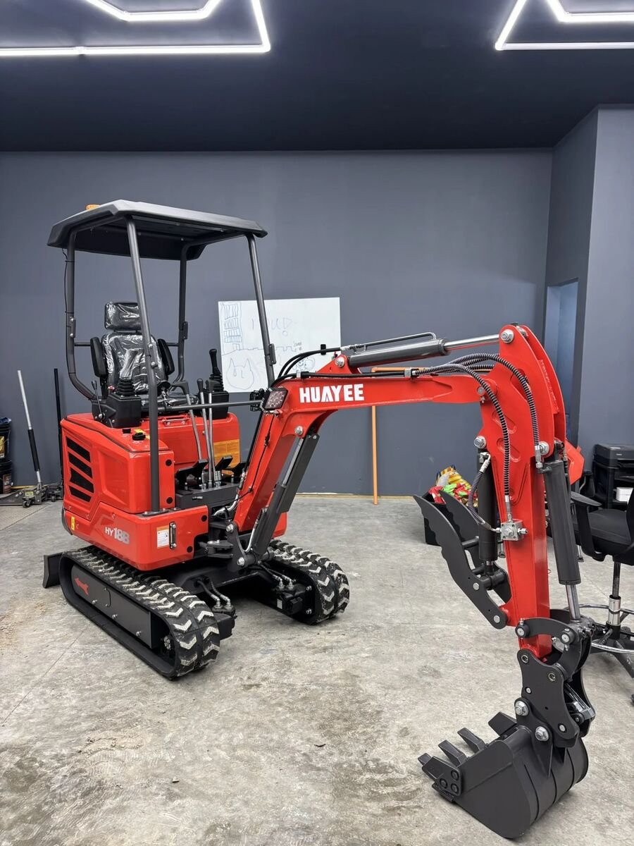 Red Huayee HY18B mini excavator with canopy and bucket resting on a shop floor